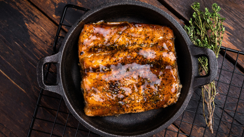 Glossy marinated baked salmon in cast iron skillet
