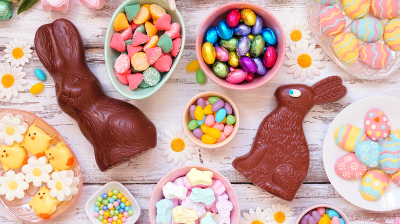 Tablescape of brightly colored Easter candy and two chocolate rabbits