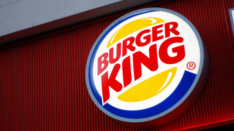 the Burger King sign lit up against a red backdrop at a restaurant