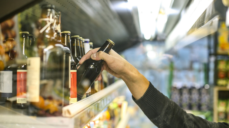 Person choosing beer bottle in store
