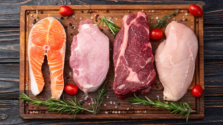Various meats and fish on wooden board
