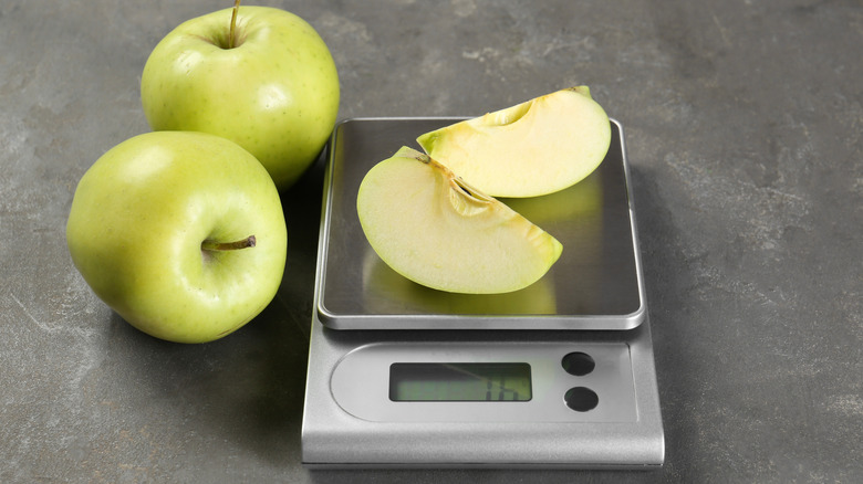 A kitchen scale weighing apples