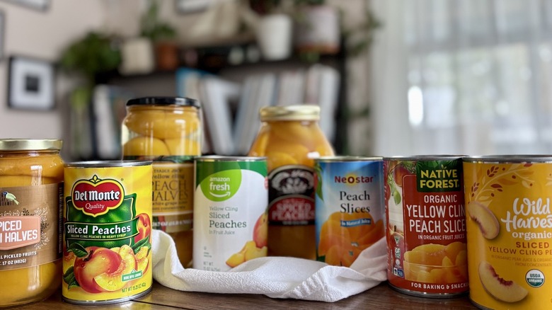 canned peaches arranged on a table in front of window