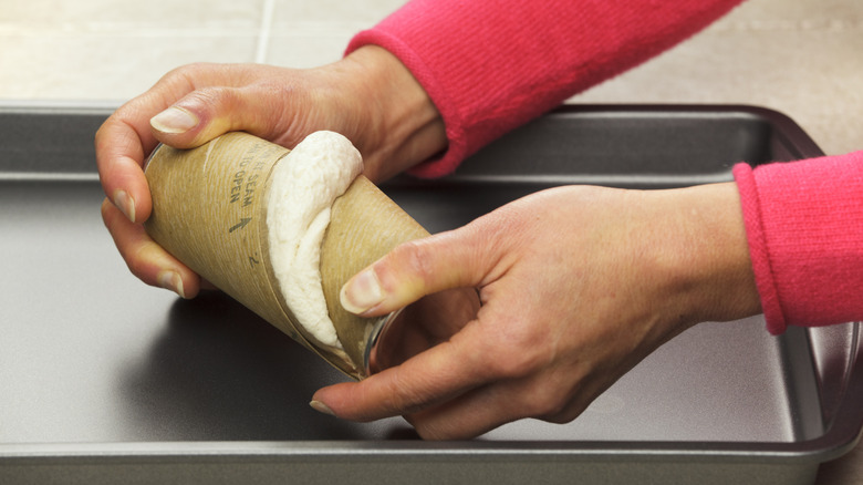 Hands opening canned biscuits