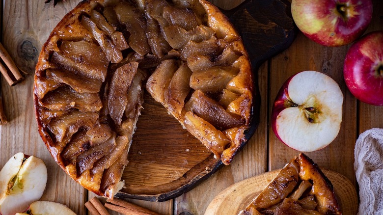 Freshly made apple pie with cinnamon roll crust sitting on a wooden table