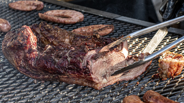 Steak and sausages cooking on an Argentine asado