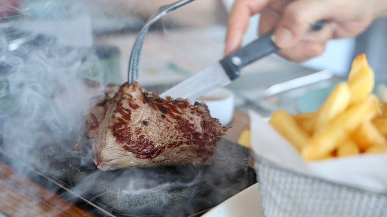 Steak cooking on a stone