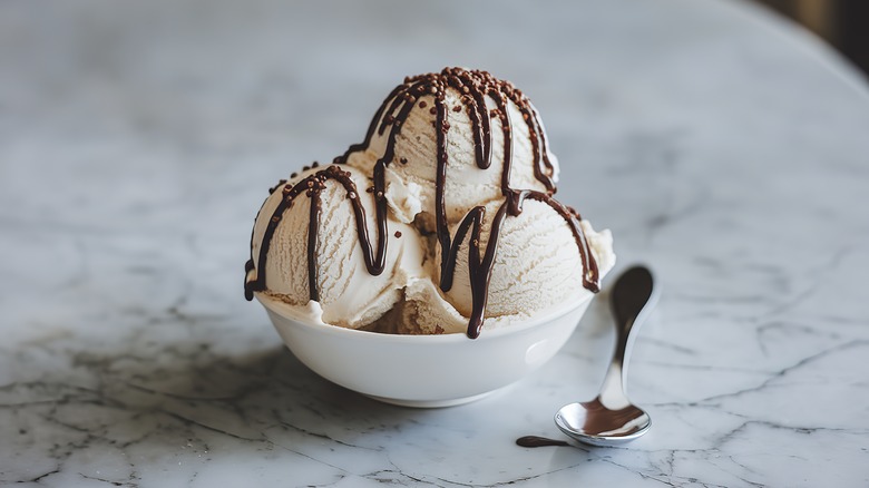 A bowl of ice cream with chocolate sauce on top