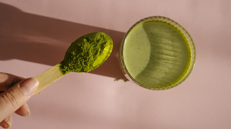 A spoonful of matcha alongside tea
