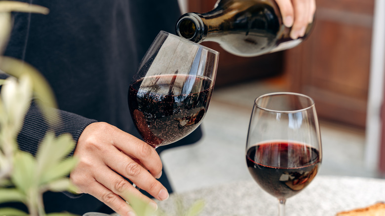 Hand pouring a glass of red wine