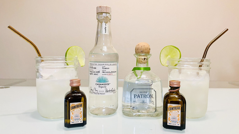 Bottles of Casamigos and Patrón tequila with margaritas and Cointreau