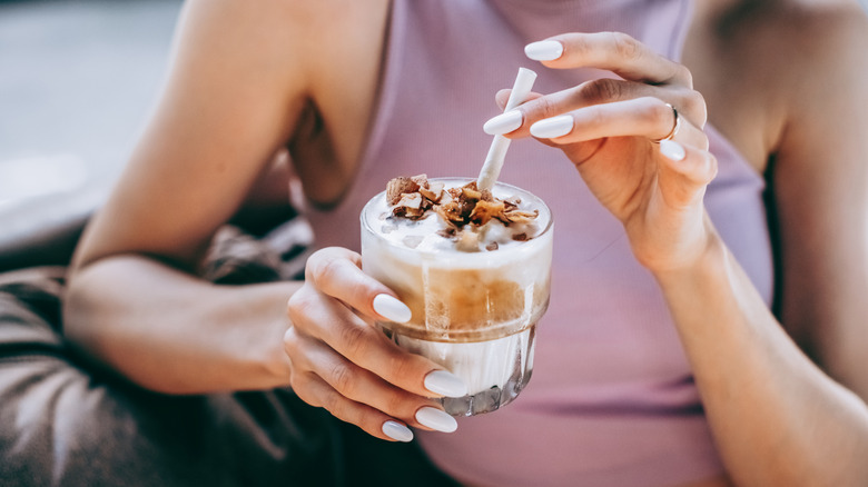 Woman drinking iced coffee with coconut flakes