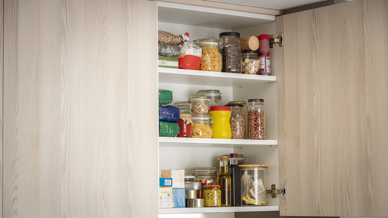 An open kitchen cabinet displays items inside