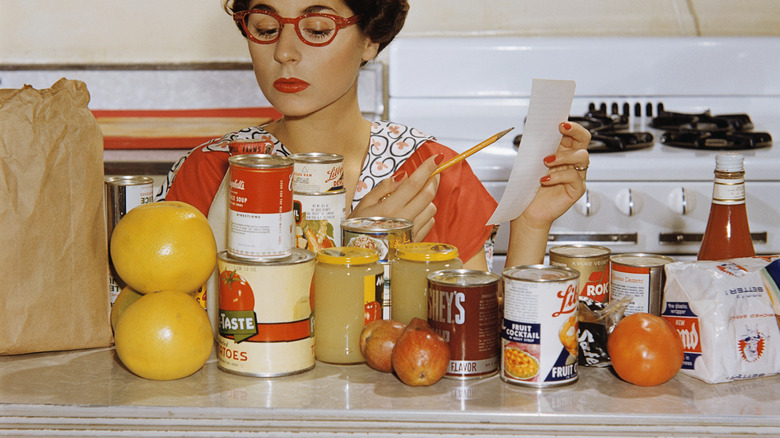 woman in kitchen with various groceries 1960s