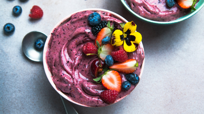 acai bowls with blueberries and strawberries in the background