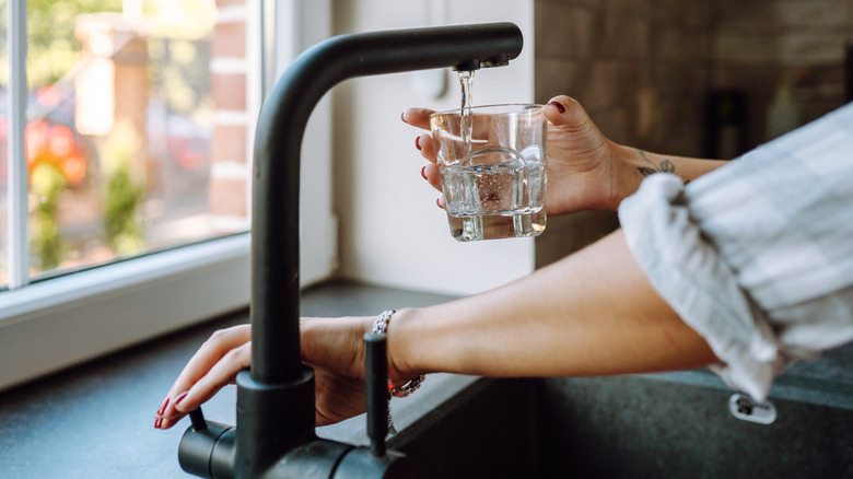 water being poured from a tap into a cup