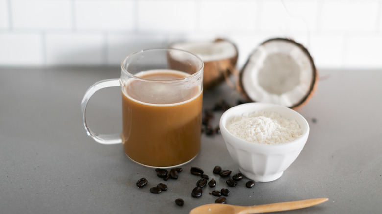 Cup of coffee beside bowl of creamer