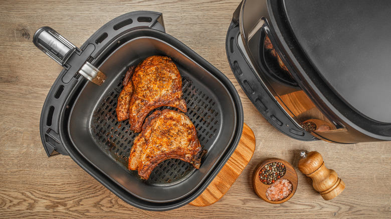 Seasoned pork chops in air fryer basket