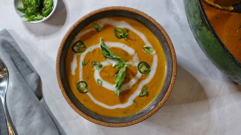 bowl of coconut pumpkin soup with basil and chiles