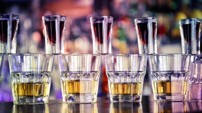 Four pint glasses with Red Bull and five shot glasses balances on top with Jagermeister between them
