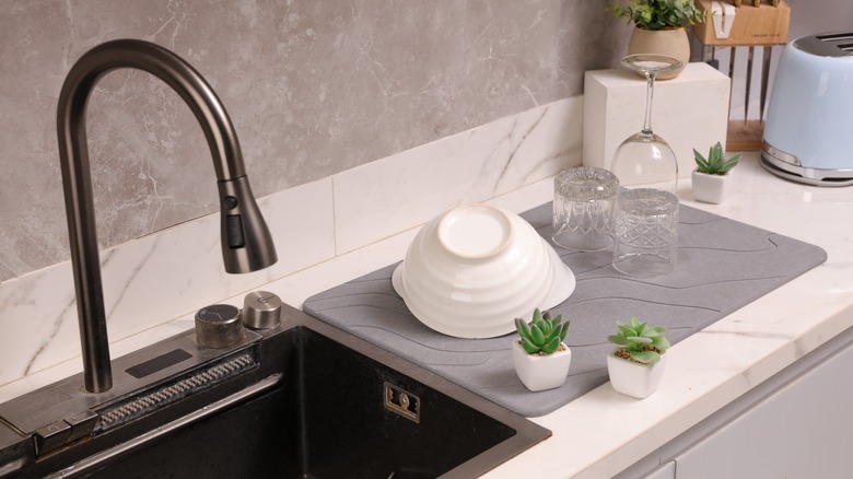 Dishes on a drying mat next to a kitchen sink