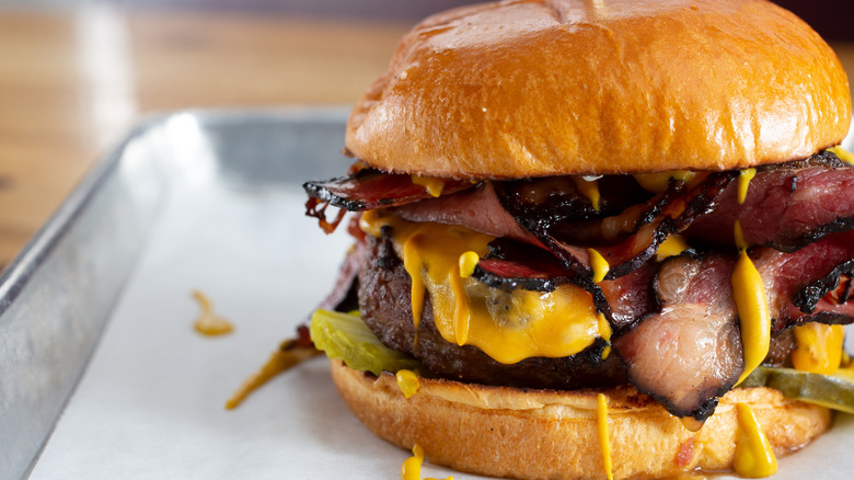 A closeup of a pastrami burger with American cheese