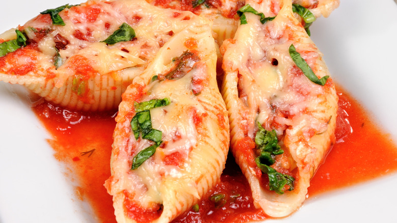 Close up view of stuffed shells with cheese and basil filling