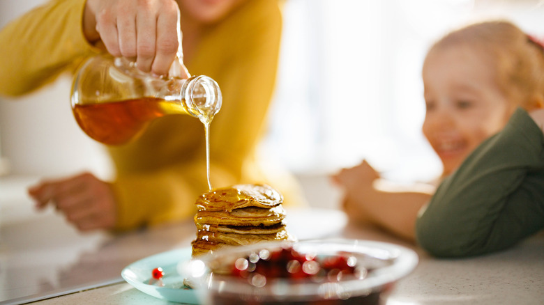 Maple syrup poured on pancakes