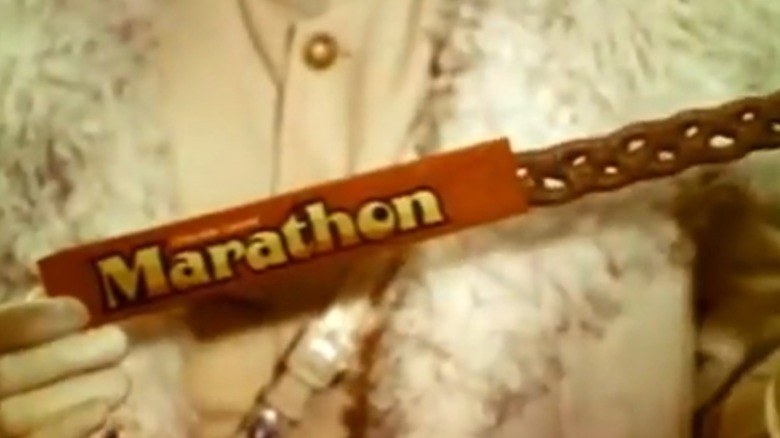 Image from 1970s Marathon candy commercial showing braided Marathon Bar being pulled out of package by man in white clothing