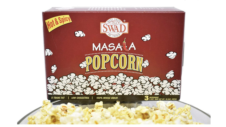 A box of Swad Masala popcorn above a bowl of popcorn