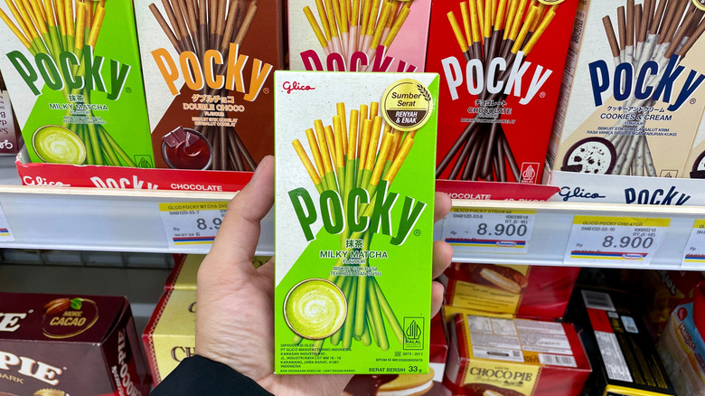 Hand holding box of matcha-flavored Pocky sticks