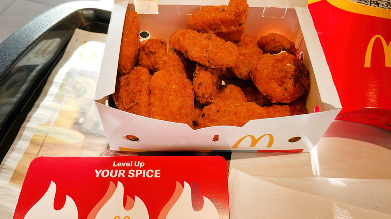 A container of McNuggets with hot sauce
