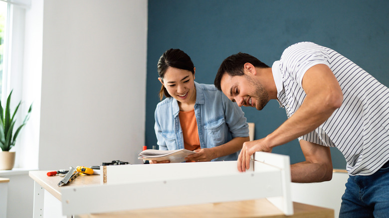 Two people assembling furniture