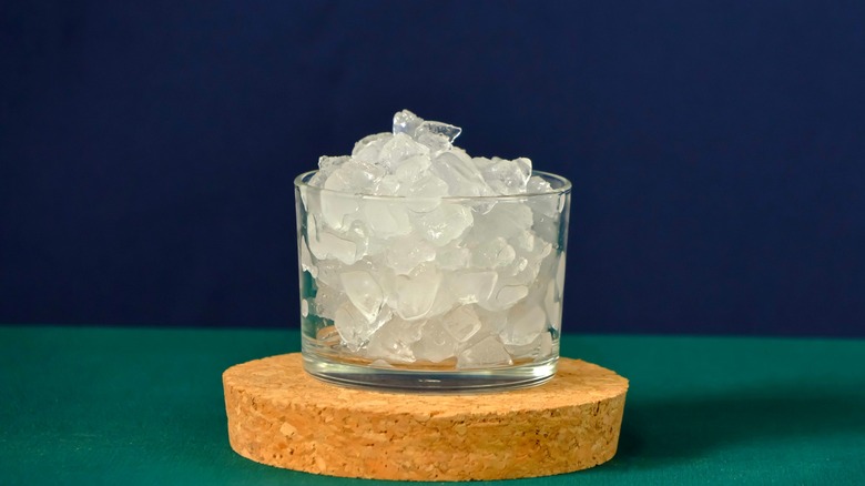 Glass of pebble ice on brown cork