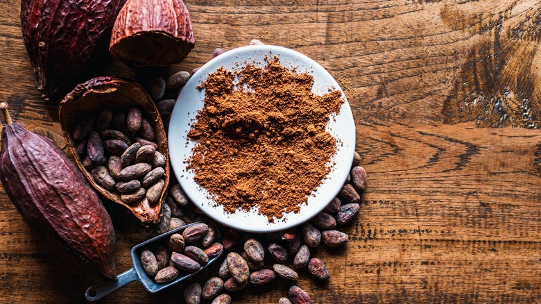 cocoa powder with cacao beans on wooden table