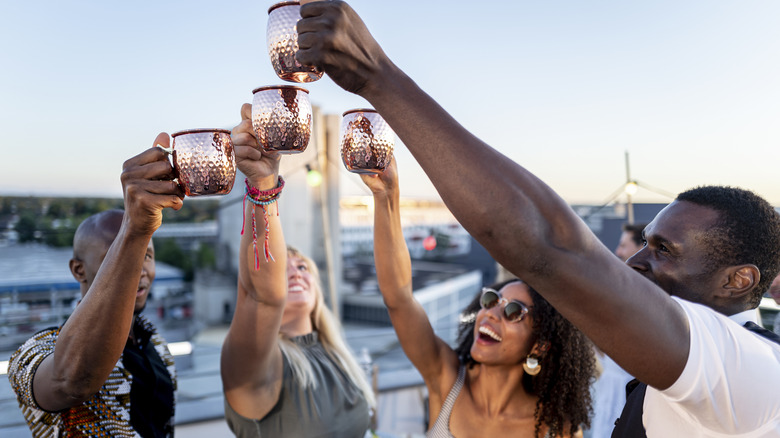 Friends raise copper glasses of Moscow mules