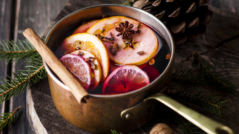Copper pot of mulled wine with cinnamon sticks and orange slices