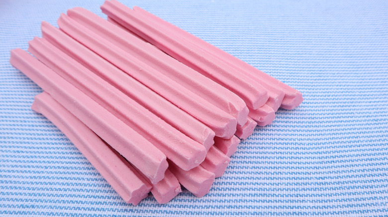 A pile of musk stick candies on a blue tablecloth