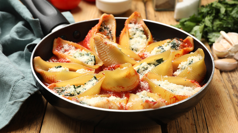 A pan of stuffed shells on a wooden table