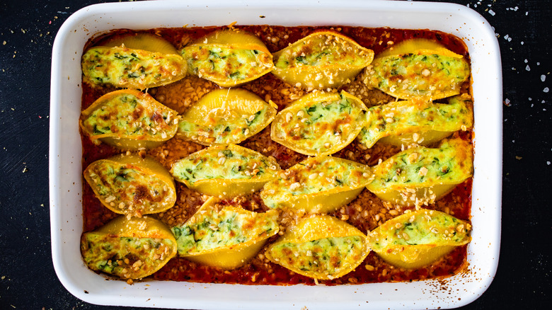A white tray of stuffed shells on a black table