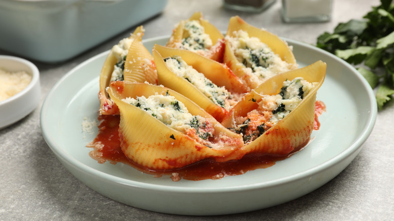 A gray plate with stuffed shells with ricotta mixture