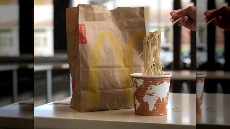 A McDonald's bag sits on a table next to a bowl of its discontinued saimin