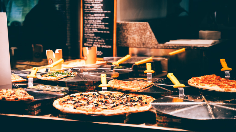 Pizzas in a pizzeria display case