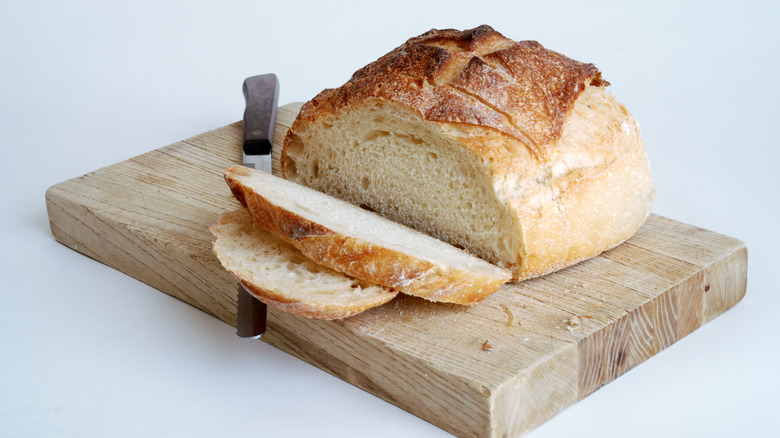 artisan bread loaf on wooden cutting board with knife