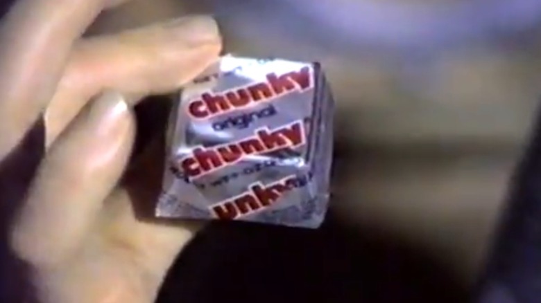 Image from commercial for Chunky candy bars circa early 1980s showing man's hand holding silver-wrapped original Chunky bar