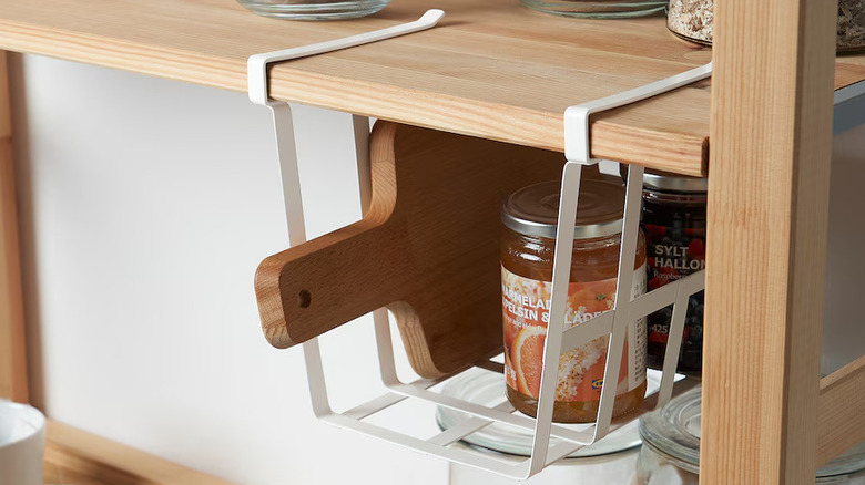 Hanging wire rack holding jars in kitchen