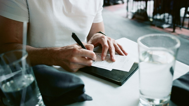 Person signing a restaurant check