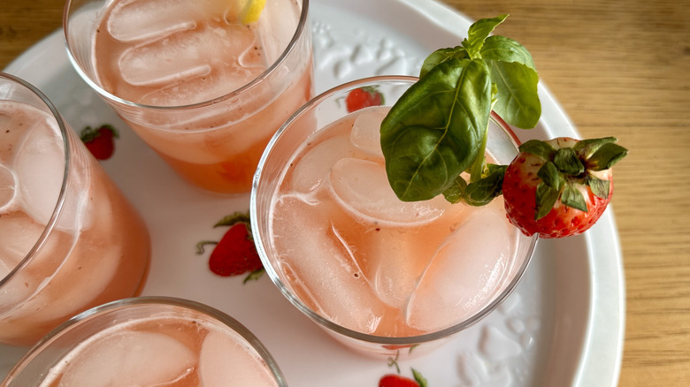 pink lemonade garnished with strawberries and basil