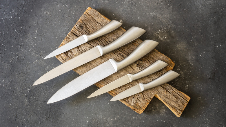 Set of modern sharp kitchen knives on dark background