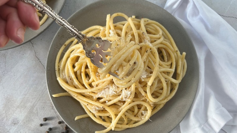 bucatini cacio e pepe twirled on fork